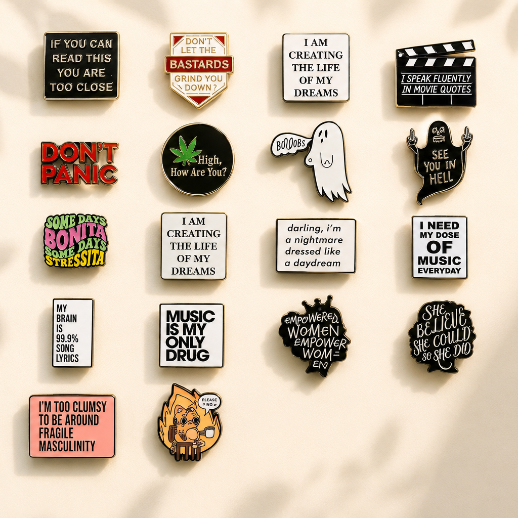 Collection of colourful quote and slogan enamel pins arranged on a warm cream background with soft natural light and botanical shadows.